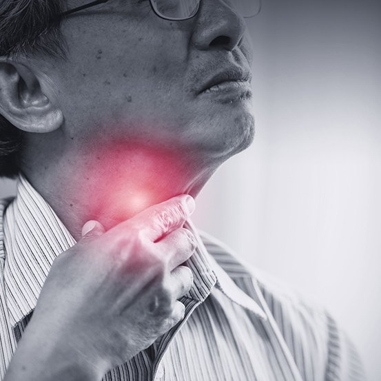 Man experiencing oral cancer symptom holding throat