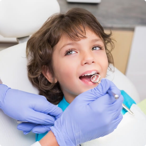 Child receiving dental checkup and teeth cleaning from children's dentist