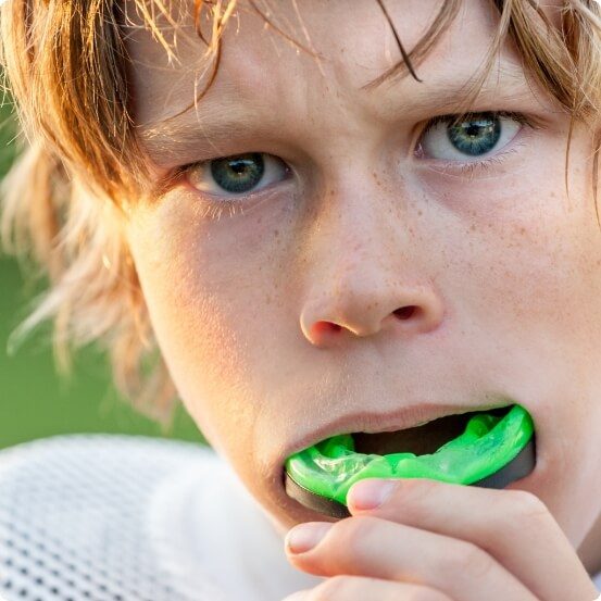 Teen placing an athletic mouthguard