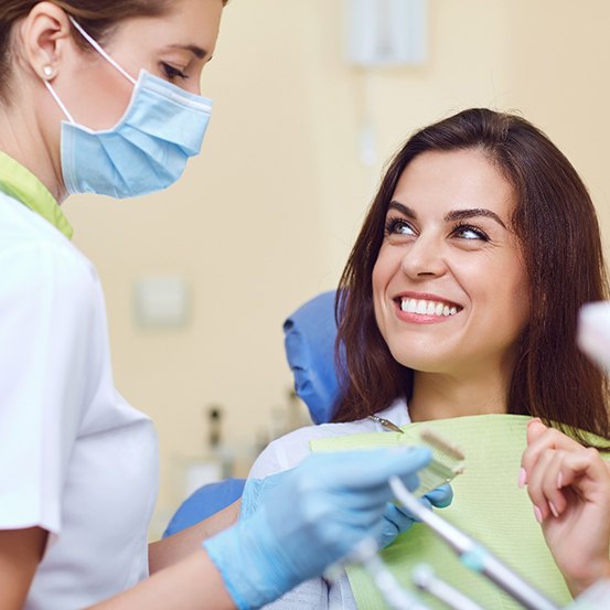 a patient smiling after receiving her dental crown