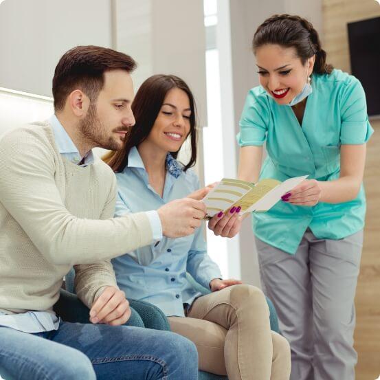 Dental team member showing dentistry patients dental insurance forms