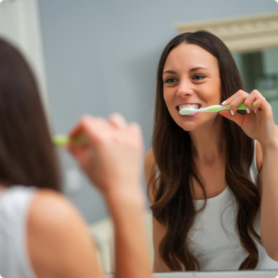 Woman brushing teeth to prevent dental emergencies