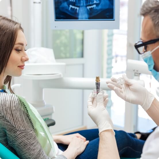 Dentist describing the four step dental implant process