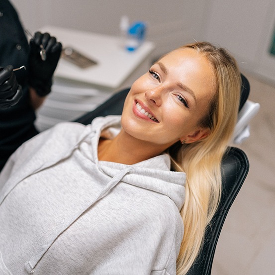 Patient reclined in treatment chair smiling