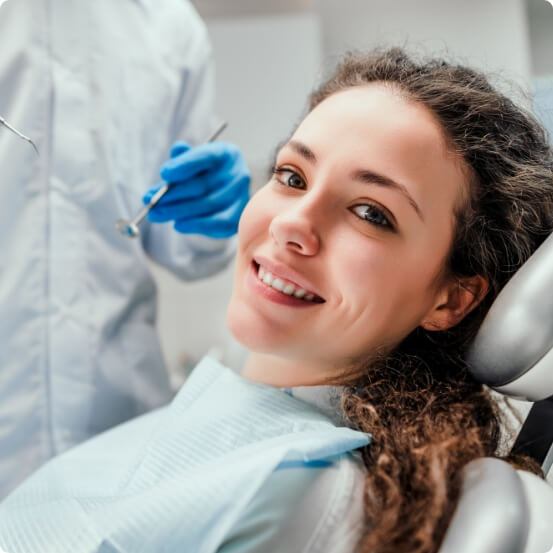 Woman smiling during preventive dentistry checkup and teeth cleaning visit