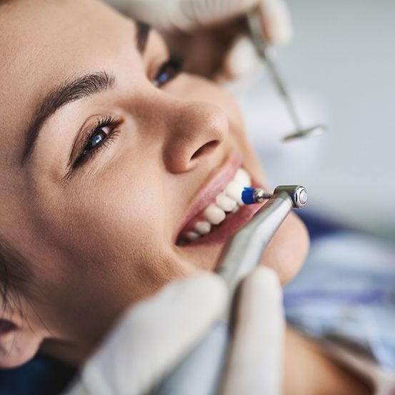 a woman having her teeth cleaned by a dentist