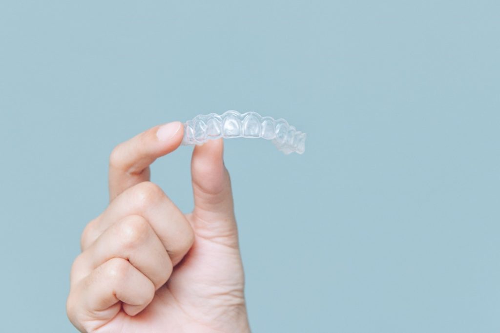 hand holding Invisalign tray