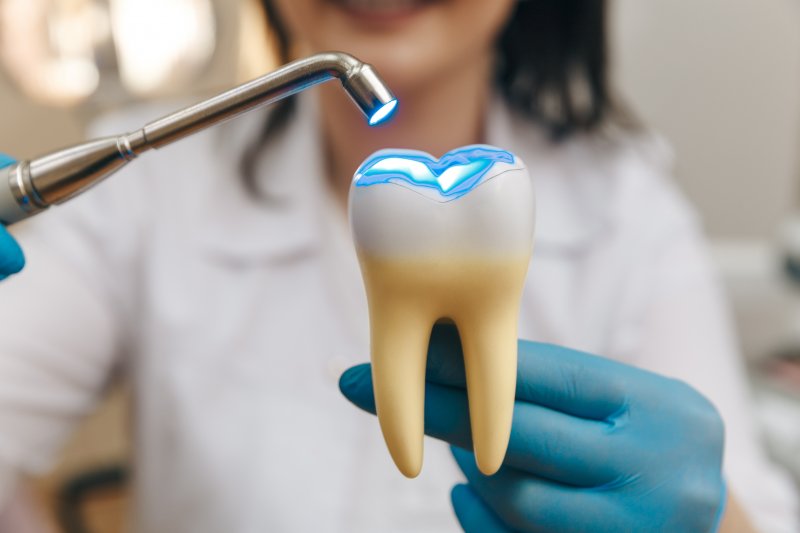 A dentist demonstrating how to cure a dental filling