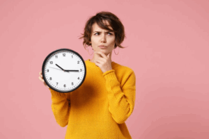 Woman holding a clock while making a questioning pose